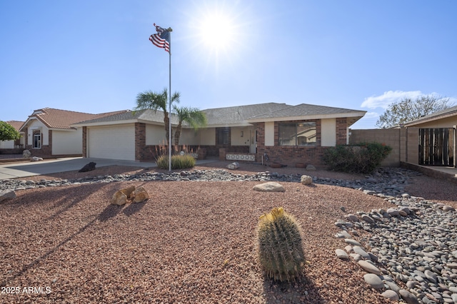 single story home with a garage, driveway, brick siding, and fence