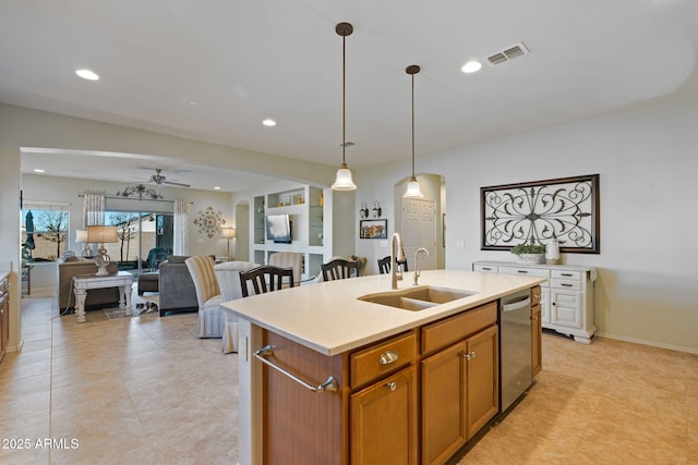 kitchen with sink, ceiling fan, an island with sink, decorative light fixtures, and stainless steel dishwasher