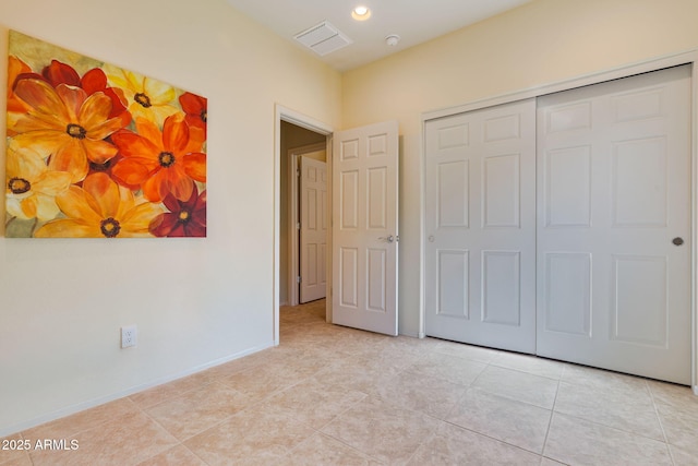 unfurnished bedroom with light tile patterned flooring and a closet