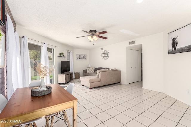 living area with visible vents, ceiling fan, a textured ceiling, and light tile patterned floors