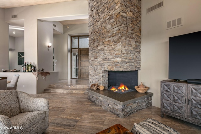 living room with a high ceiling, hardwood / wood-style floors, and a fireplace