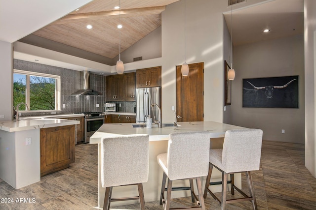 kitchen featuring sink, wall chimney exhaust hood, stainless steel appliances, and an island with sink