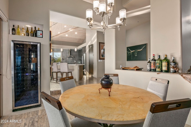 dining room featuring wine cooler, bar area, vaulted ceiling, and an inviting chandelier