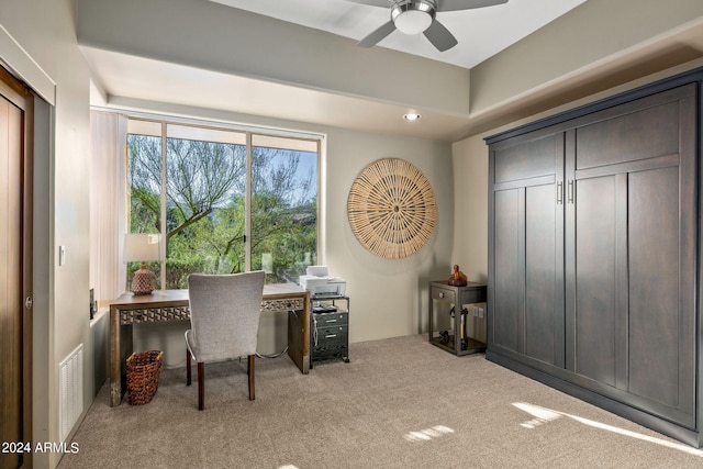 carpeted office space with ceiling fan