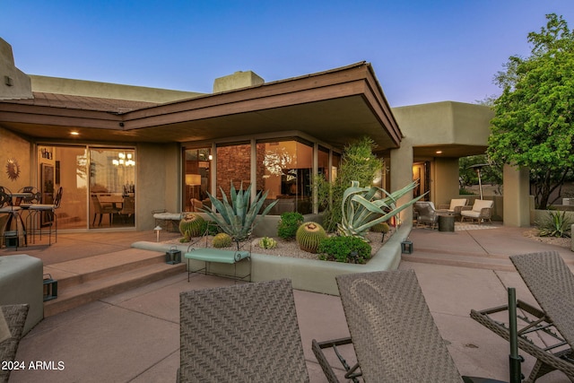 back house at dusk with an outdoor hangout area and a patio