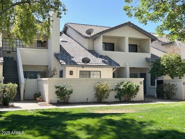 view of front of home featuring a fenced front yard, a chimney, a tile roof, and a front yard