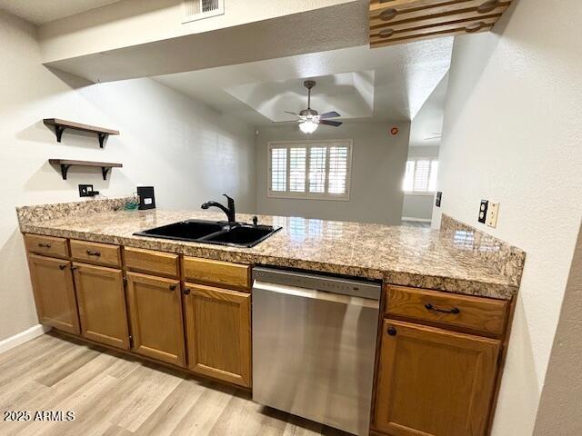 kitchen with a sink, dishwasher, brown cabinets, a peninsula, and open shelves