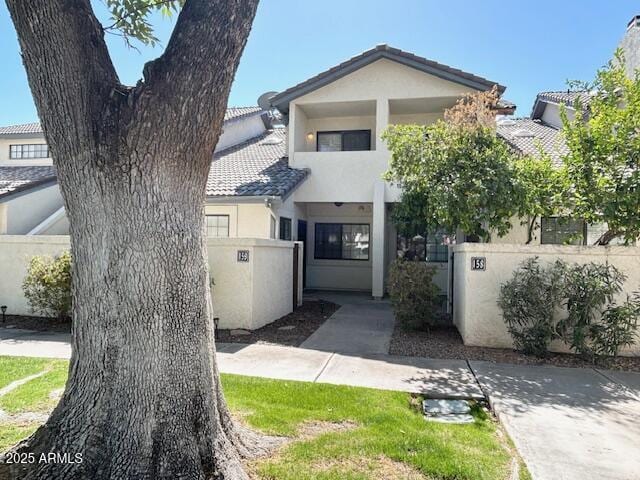 view of front of house featuring stucco siding, a fenced front yard, and a tile roof