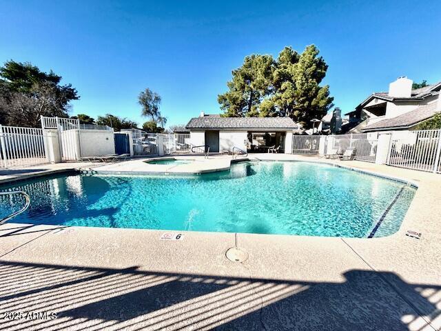 community pool featuring fence and a patio area