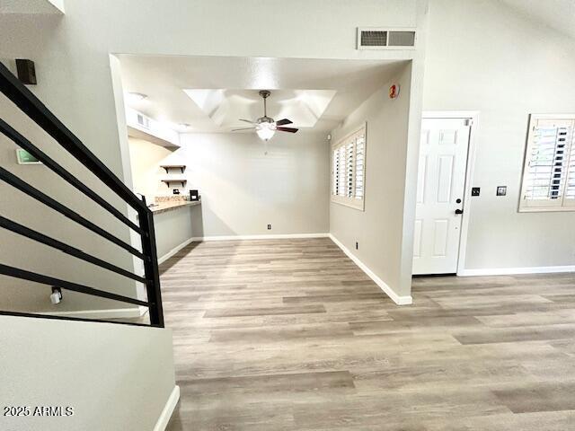 foyer with visible vents, stairway, a ceiling fan, and wood finished floors