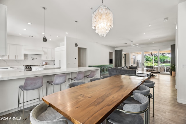 dining area with ceiling fan with notable chandelier and dark hardwood / wood-style floors