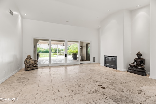 unfurnished living room featuring a towering ceiling