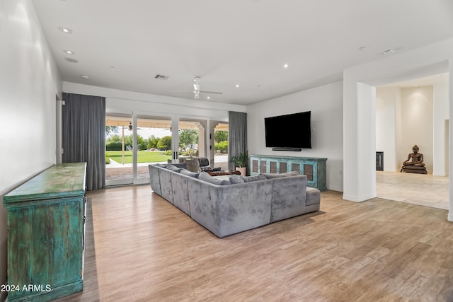 living room featuring ceiling fan and light hardwood / wood-style floors