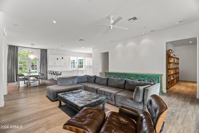 living room featuring ceiling fan, plenty of natural light, and light hardwood / wood-style floors