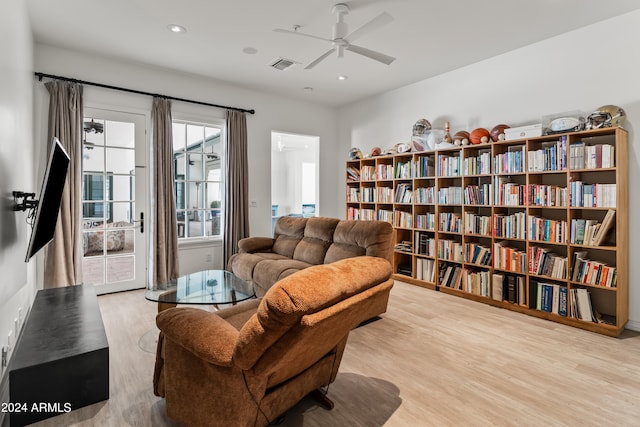 living area with ceiling fan and light hardwood / wood-style flooring