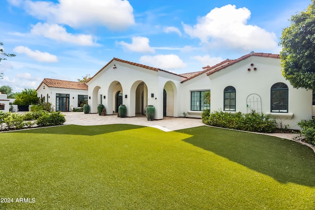 back of property with a patio area and a yard