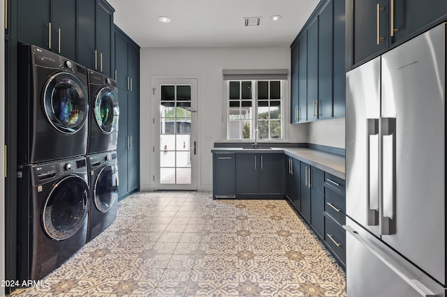 washroom featuring washing machine and clothes dryer, sink, cabinets, light tile patterned floors, and stacked washer and clothes dryer