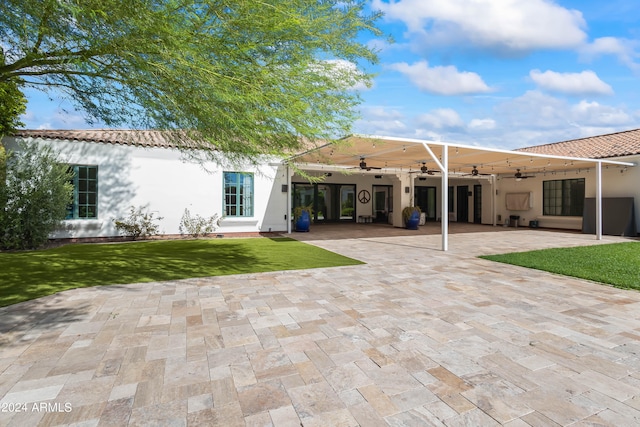 rear view of house featuring a lawn, a patio area, and ceiling fan