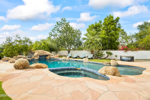 view of swimming pool with an in ground hot tub