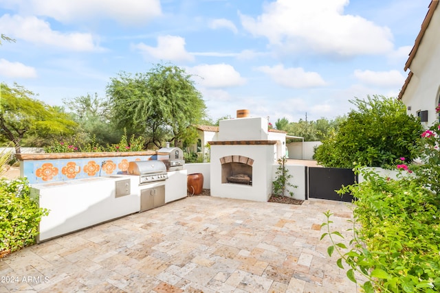 view of patio / terrace featuring a grill, area for grilling, and an outdoor fireplace