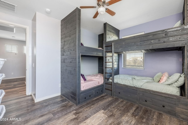 bedroom featuring ceiling fan, dark wood-type flooring, and multiple windows