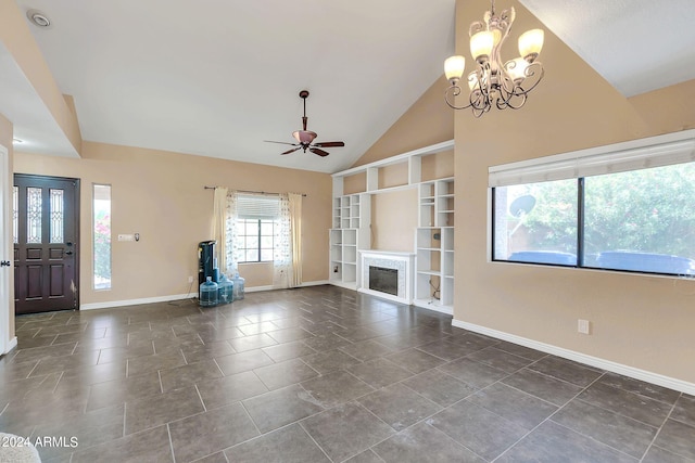 unfurnished living room with dark tile patterned flooring, ceiling fan with notable chandelier, and vaulted ceiling