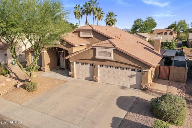 1015 E Constitution Dr, Gilbert, AZ 85296 - mediterranean / spanish-style house featuring stucco siding, a gate, concrete driveway, an attached garage, and a tiled roof
