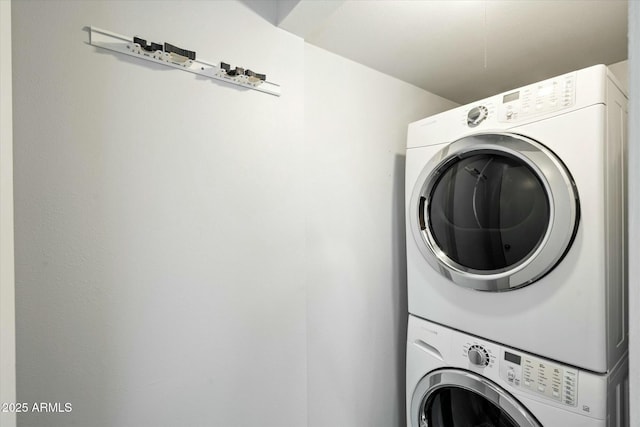 clothes washing area featuring stacked washer and dryer