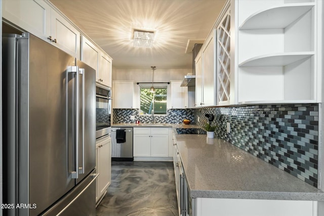 kitchen with sink, appliances with stainless steel finishes, hanging light fixtures, white cabinets, and decorative backsplash