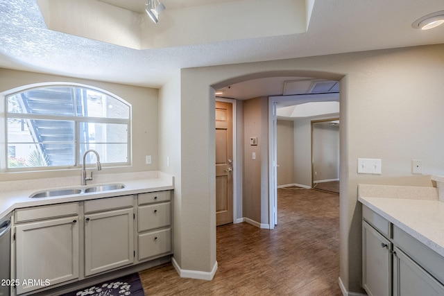 kitchen with sink, hardwood / wood-style floors, and stainless steel dishwasher