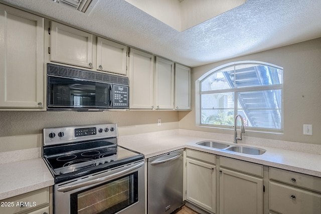 kitchen featuring sink, a textured ceiling, and appliances with stainless steel finishes