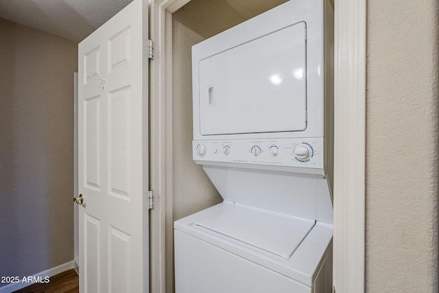 washroom with hardwood / wood-style floors, a textured ceiling, and stacked washer and dryer