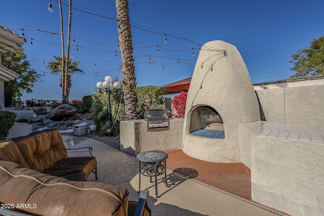 view of patio / terrace with exterior fireplace, exterior kitchen, and grilling area