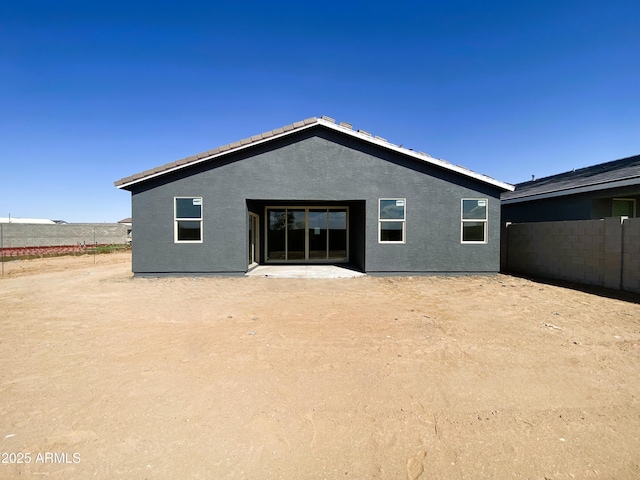 rear view of property with fence and stucco siding