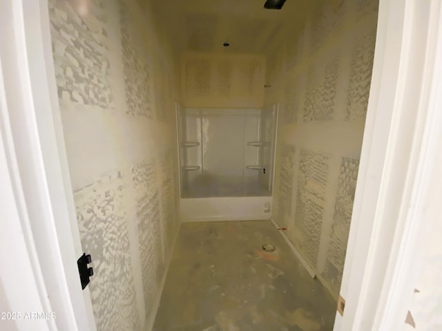 bathroom with a shower and unfinished concrete flooring