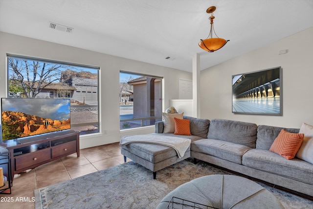 living room with tile patterned flooring, visible vents, and a healthy amount of sunlight