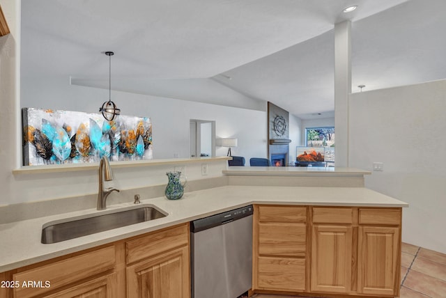 kitchen with dishwasher, light countertops, vaulted ceiling, light tile patterned floors, and a sink