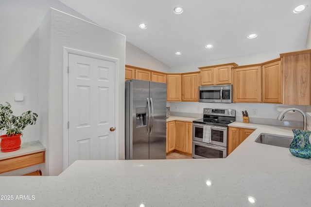 kitchen featuring a sink, vaulted ceiling, recessed lighting, and stainless steel appliances