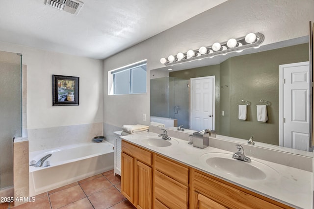 full bathroom featuring a bath, visible vents, tile patterned floors, and a sink