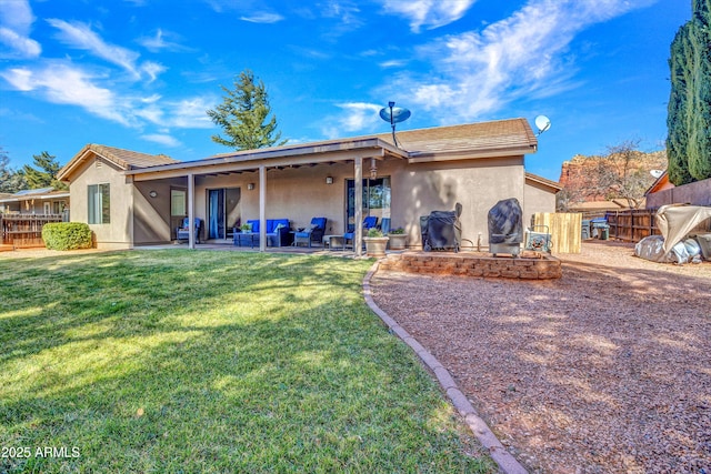 back of house with stucco siding, fence, a yard, and a patio area