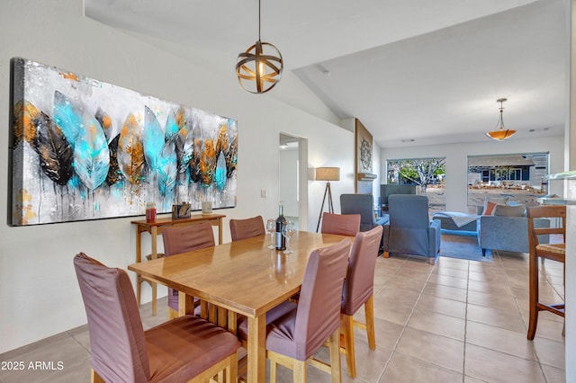 dining space with lofted ceiling and light tile patterned flooring