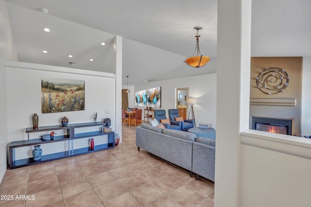 living room with visible vents, lofted ceiling, recessed lighting, light tile patterned flooring, and a glass covered fireplace