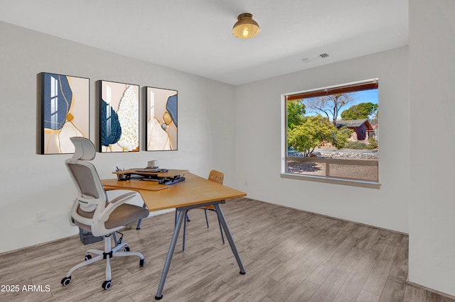 home office featuring visible vents and wood finished floors