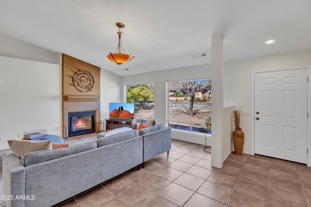 living room featuring light tile patterned flooring, visible vents, recessed lighting, and a large fireplace