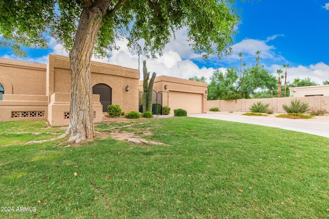 pueblo-style home with a front lawn and a garage