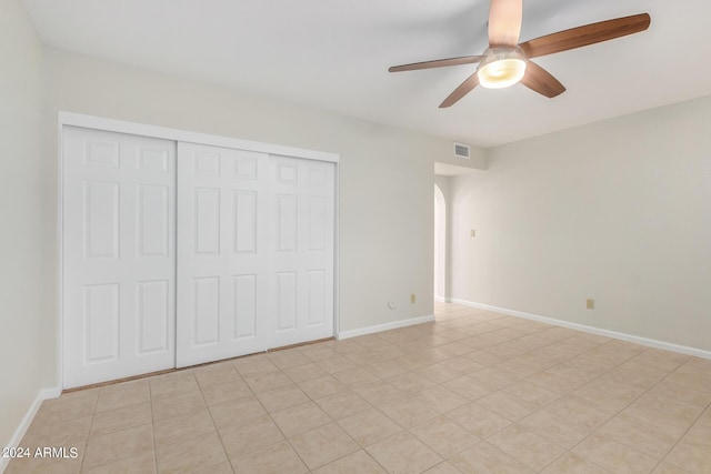 unfurnished bedroom featuring ceiling fan and a closet