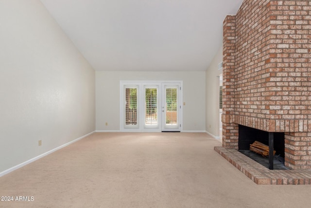 unfurnished living room featuring light carpet, high vaulted ceiling, and a brick fireplace