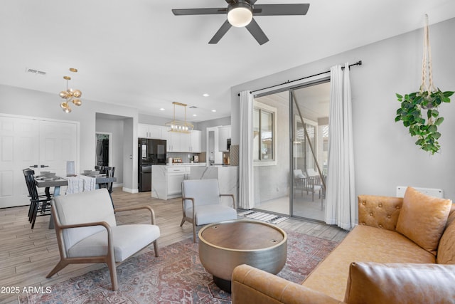 living room featuring ceiling fan, a healthy amount of sunlight, and light hardwood / wood-style floors