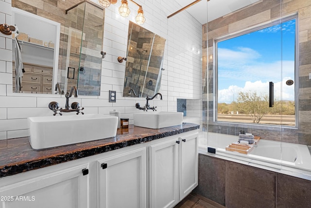 bathroom featuring backsplash, tile walls, independent shower and bath, and vanity