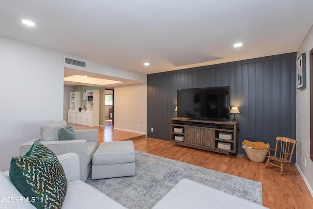 living area featuring baseboards, visible vents, light wood-style floors, and recessed lighting